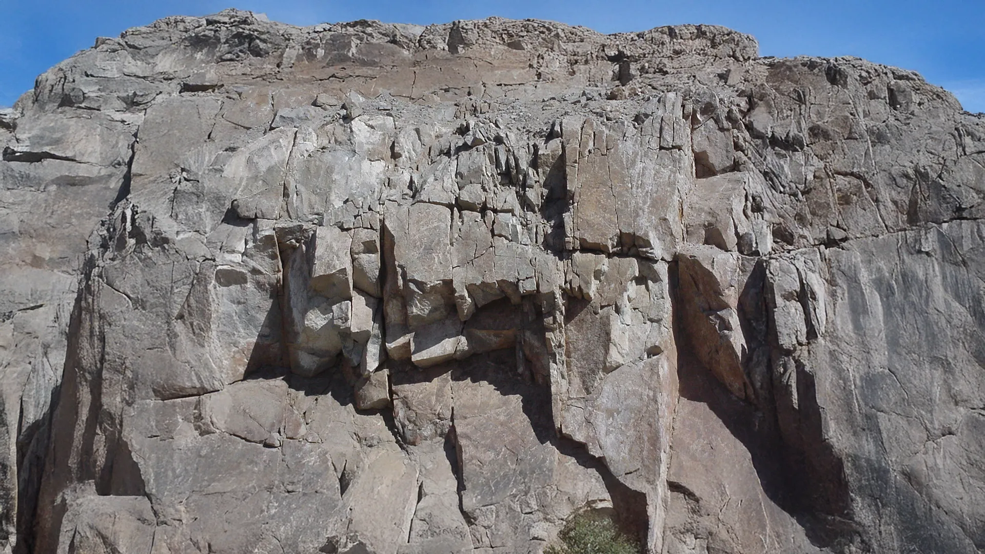 Estructura de rocas sedimentarias con fisuras visibles, útil en estudios geológicos y análisis de estabilidad del terreno
