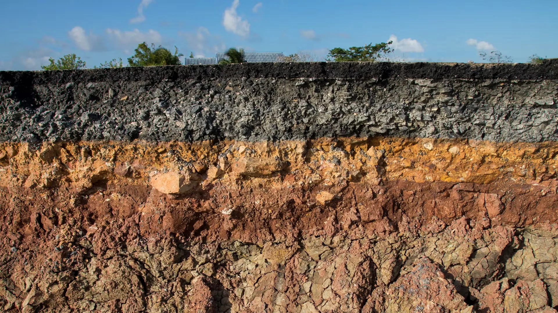 Perfil de suelo con capas diferenciadas, empleado en caracterización geológica y estudios de riesgos naturales