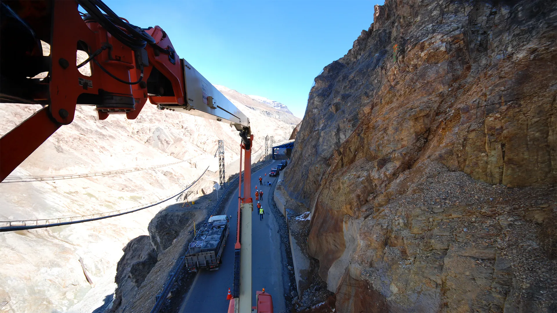 Maquinaria pesada trabaja en vía de montaña, parte del monitoreo geológico y mitigación de riesgos naturales